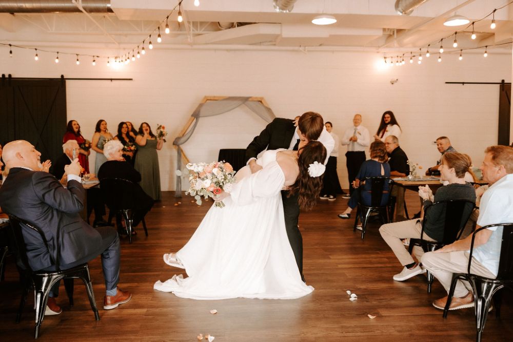 Groom dipping bride for a kiss after ceremony at BASH