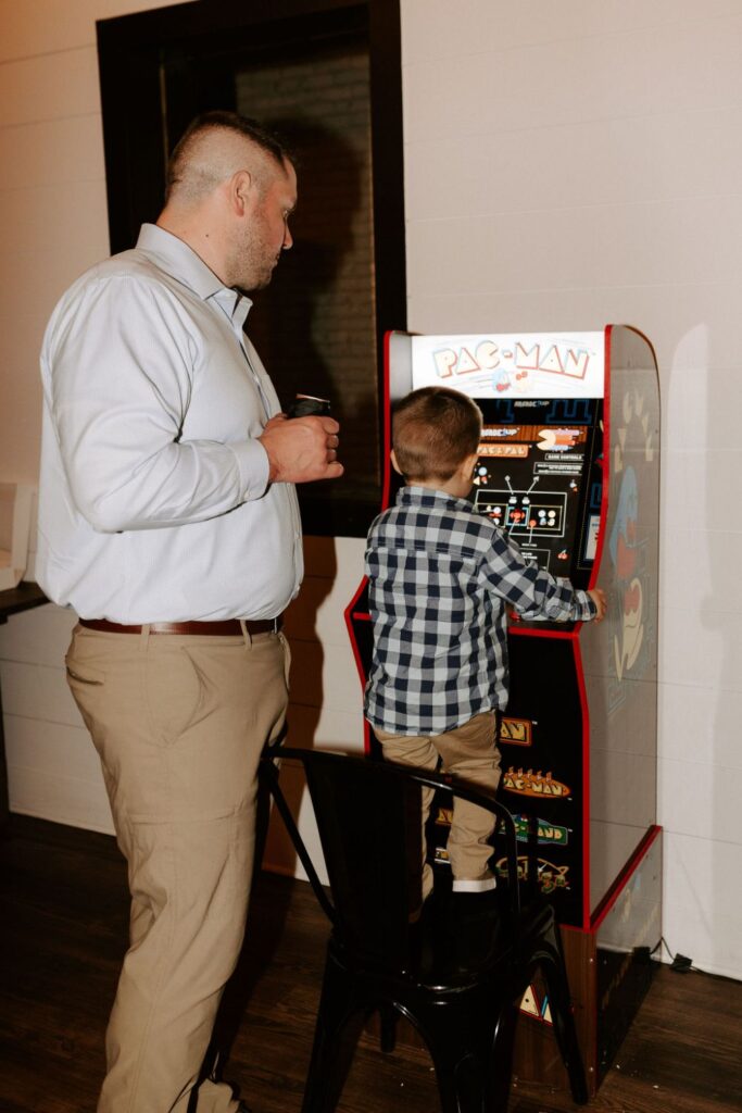 Dad and son playing arcade games at wedding at BASH