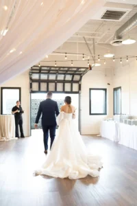 Bride and groom walking towards garage doors at BASH in carmel, IN