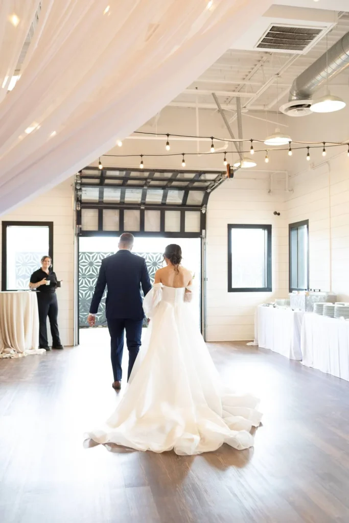 Bride and groom walking towards garage doors at BASH in carmel, IN