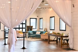 BASH set up with a lounge area and charcuterie display, tucked away in the alcove with draping surrounding the space.