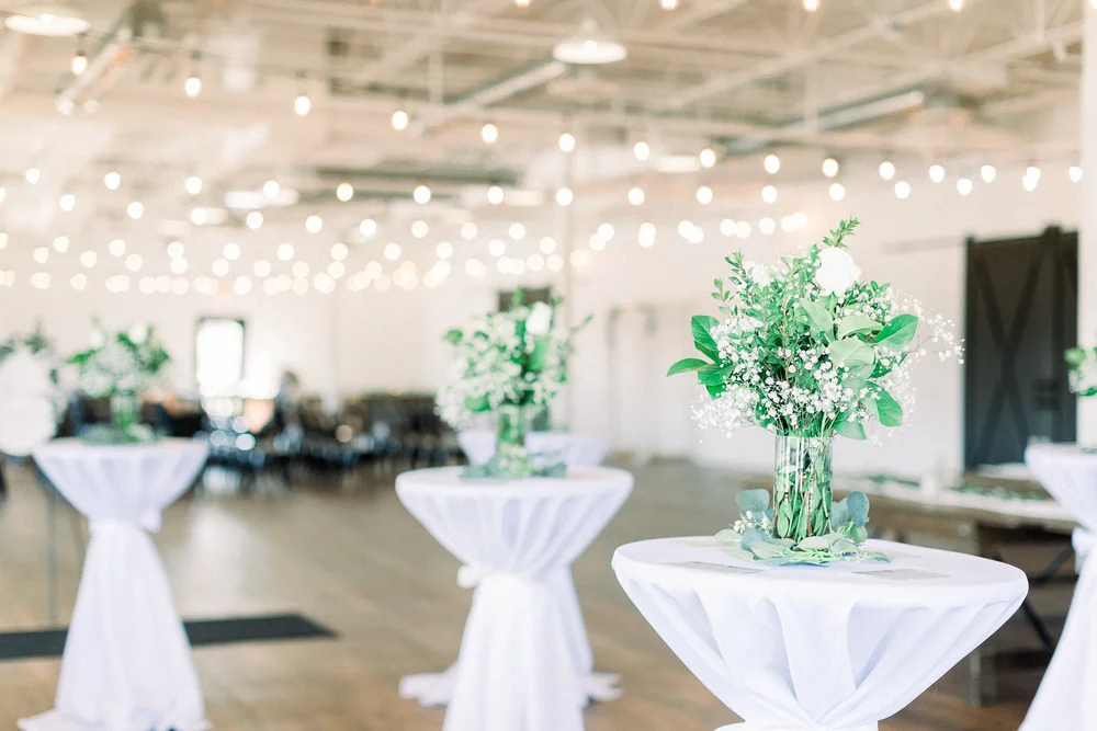 Cocktail tables set up at BASH in Carmel with white linens and florals for company holiday party.