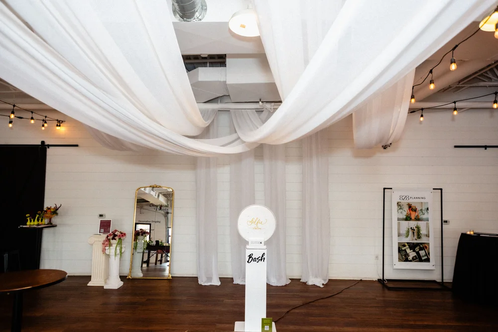 Photo booth with draping and decor at BASH, a Carmel wedding & event venue open house