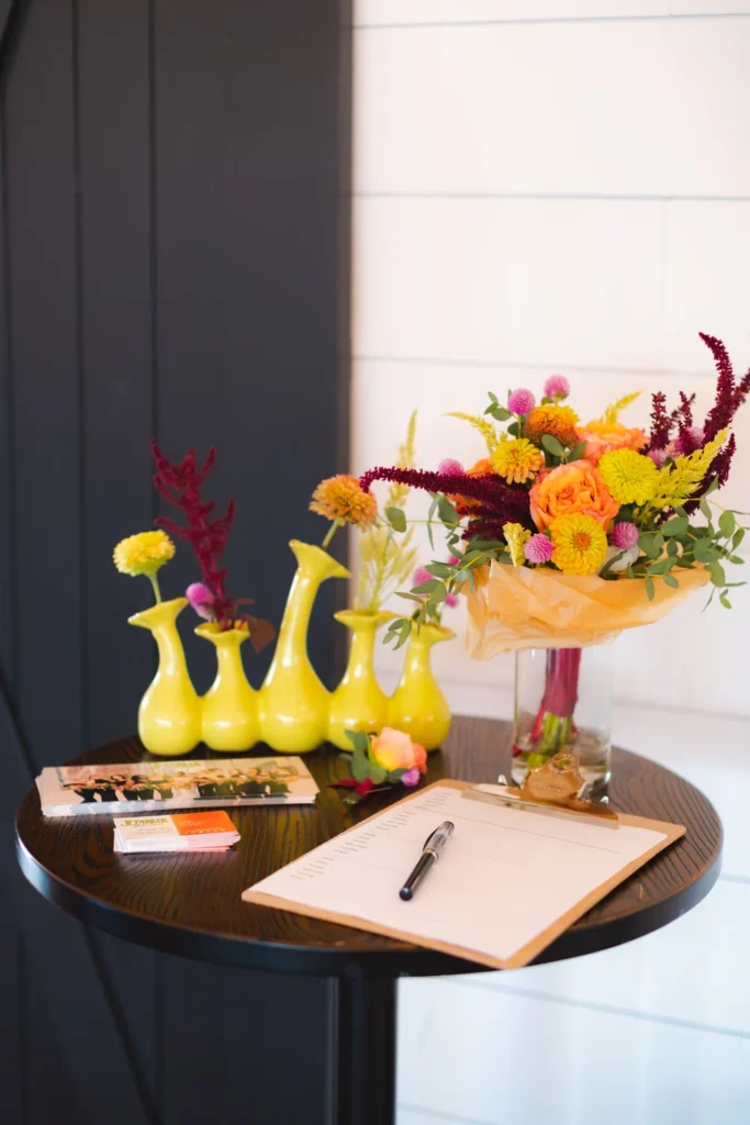 Bright vases and floral arrangements decorating a cocktail table at BASH Carmel wedding & event venue