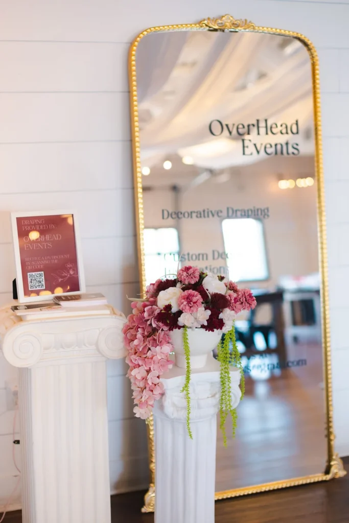 Event signage surrounded by elegant floral arrangements at BASH Carmel wedding & event venue