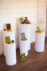 Appetizers and signage set up on white pillar stands