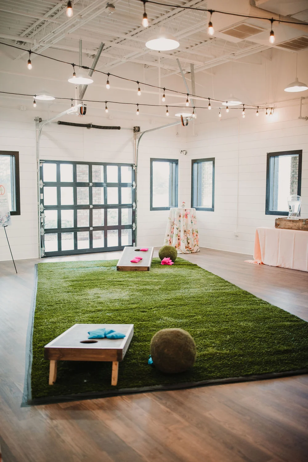 Turf rug with cornhole set up on it inside of BASH in Carmel, IN