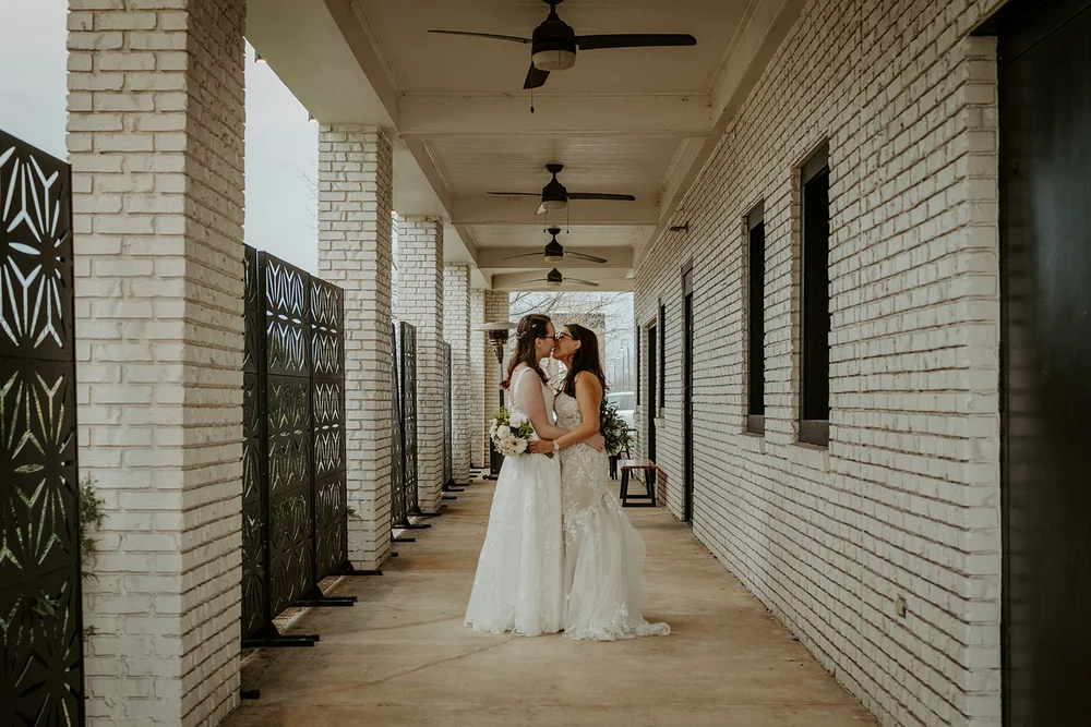 Two brides kissing on the patio at BASH Carmel, Indiana wedding venue