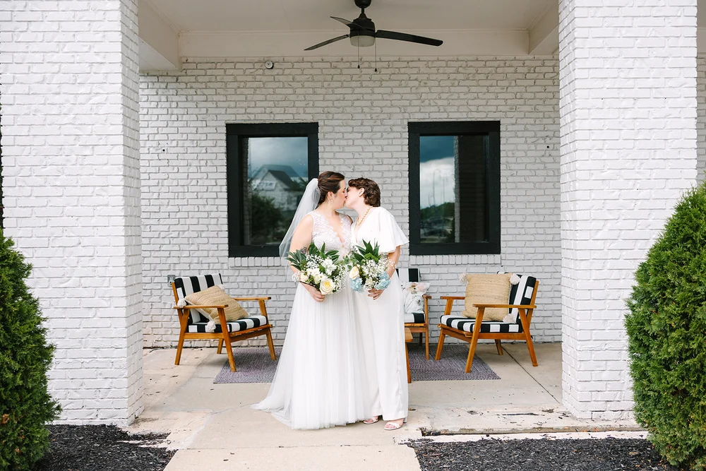 LGBTQ+ brides kissing in front of BASH wedding venue in Carmel IN